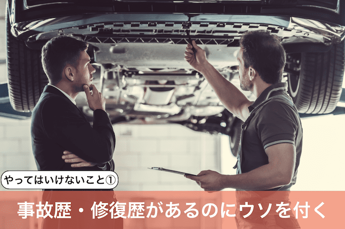 車の下回りを見る男二人