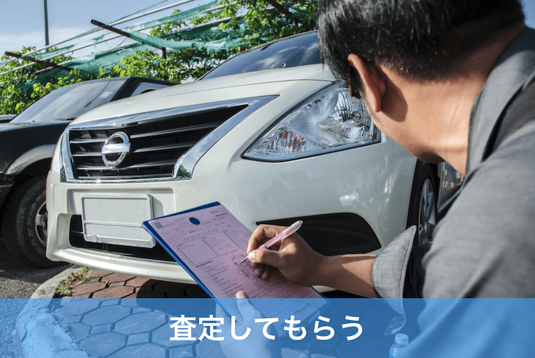 車の査定をする中年男性