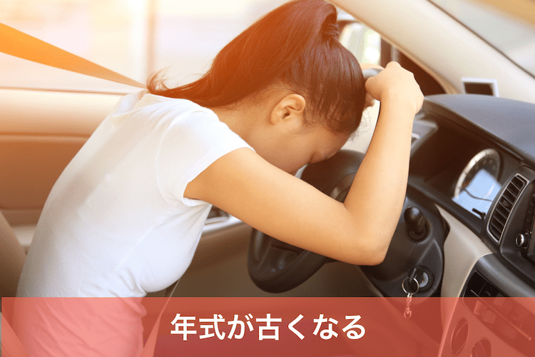 車のハンドルにもたれかかる女性