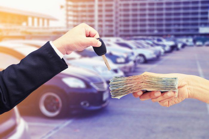 車のキーと現金を交換する人