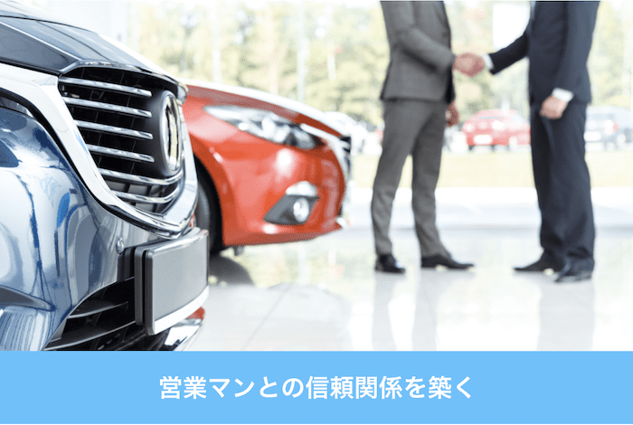 ディーラー店舗で握手を交わす男たち