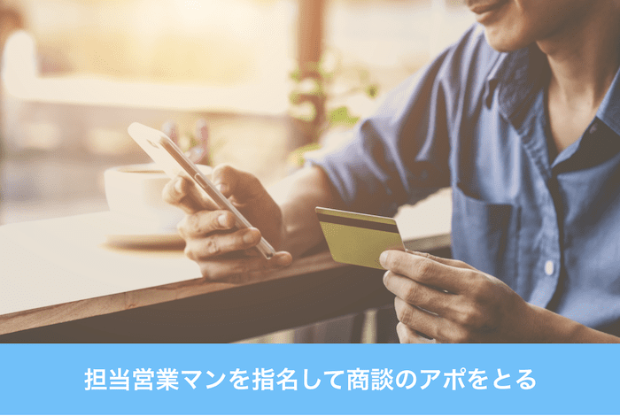 名刺を片手に電話する男