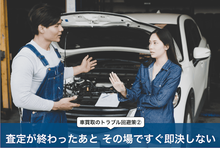 車の前で交渉する男女