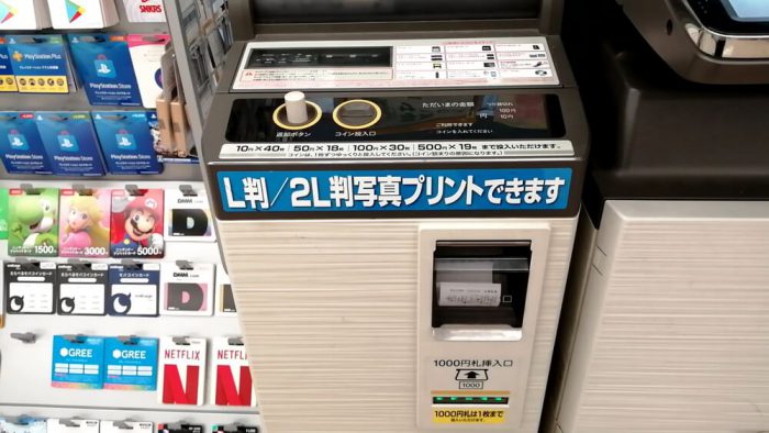 ファミリーマートのマルチコピー機の窓に領収書が出力されてきた場面