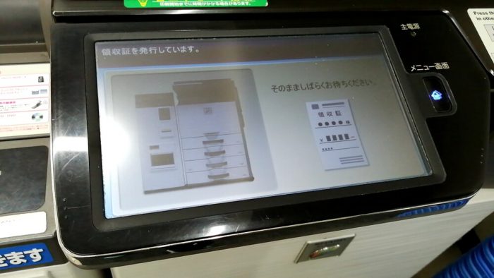 コンビニ(ローソン)店頭のファクスの操作パネル(領収証が出力中の画面)