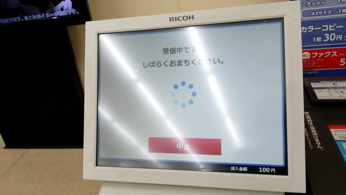 ミニストップ店頭のマルチコピー機の操作パネル（「クロネコFAX」のデータ受信中の画面）